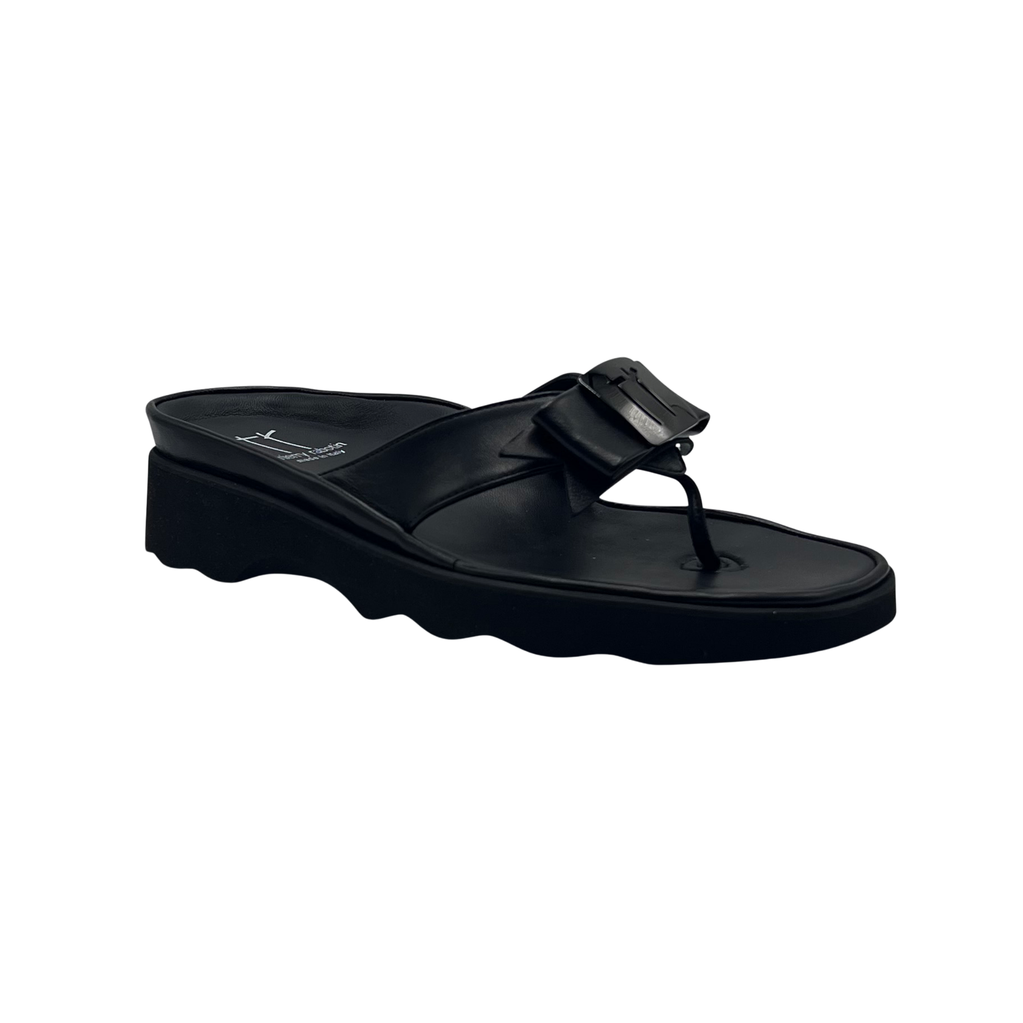 A black wedge slide sandal with a thick platform sole and a decorative buckle detail on the strap, shown against a plain white background.