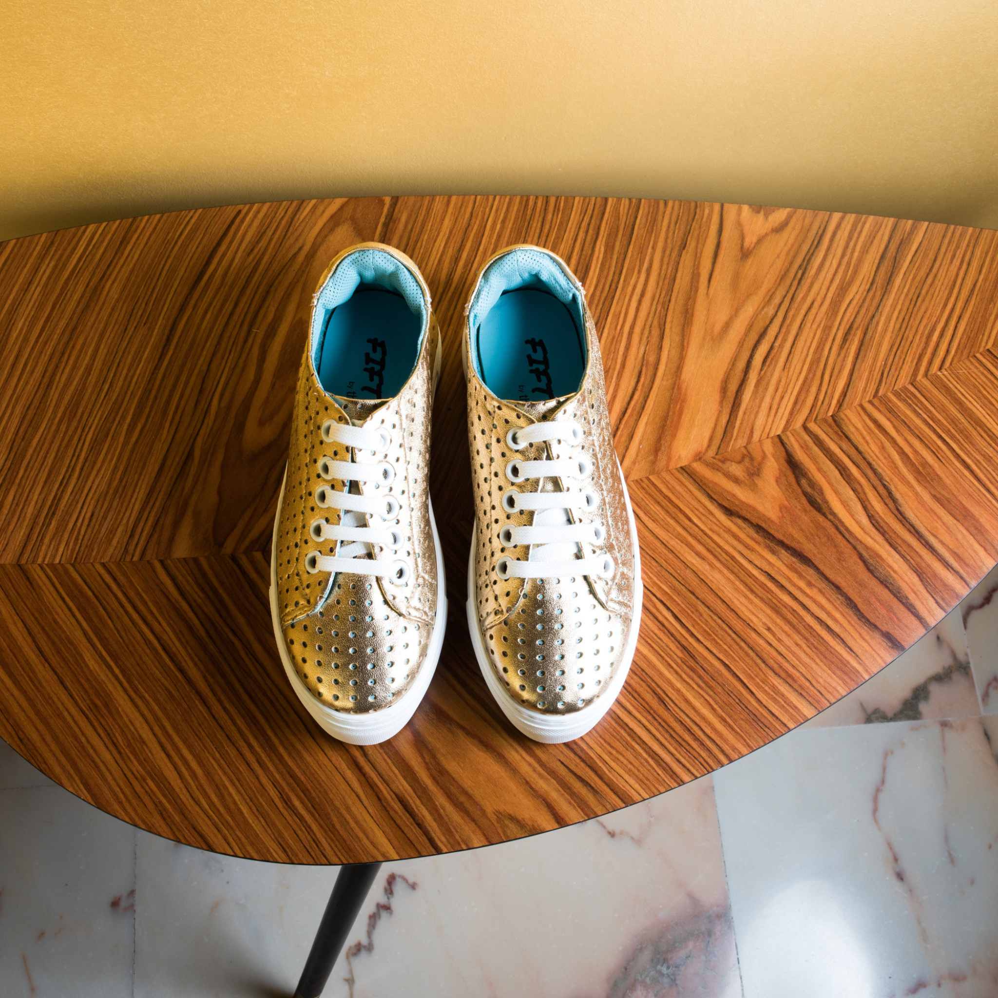 Fifty-12 Asia Lux Sneaker in Gold Metallic lambskin Nappa Leather on table