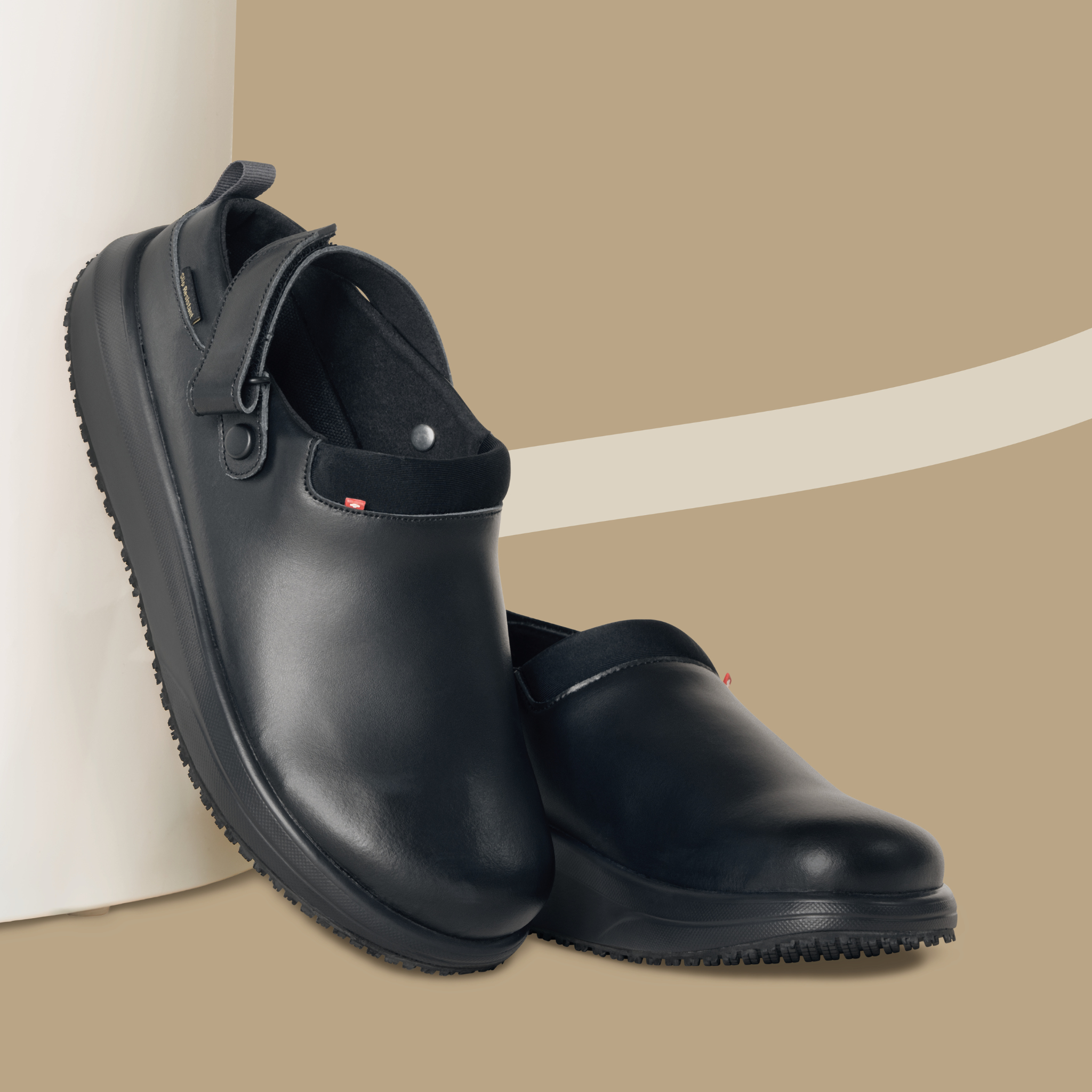 Pair of black rubber boots on a beige background