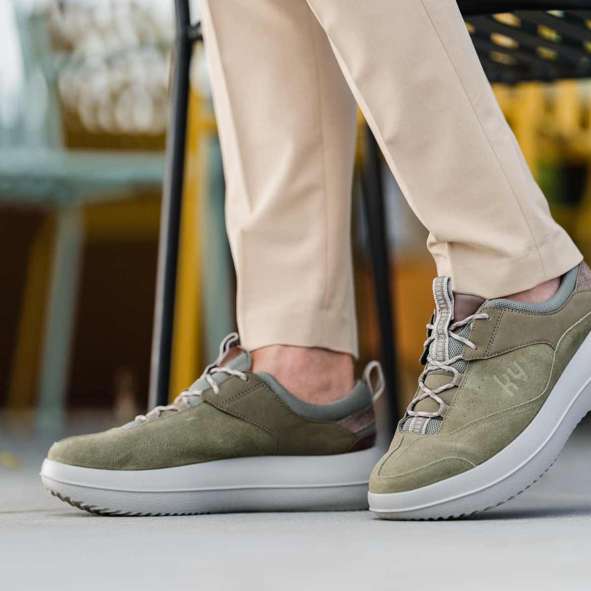 close up shot of man wearing green shoes with laces.