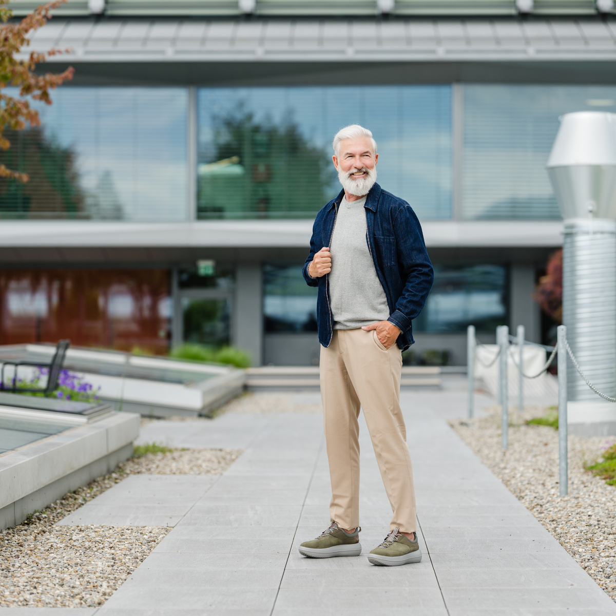 man standing in front of building wearing beige pants and green shoes