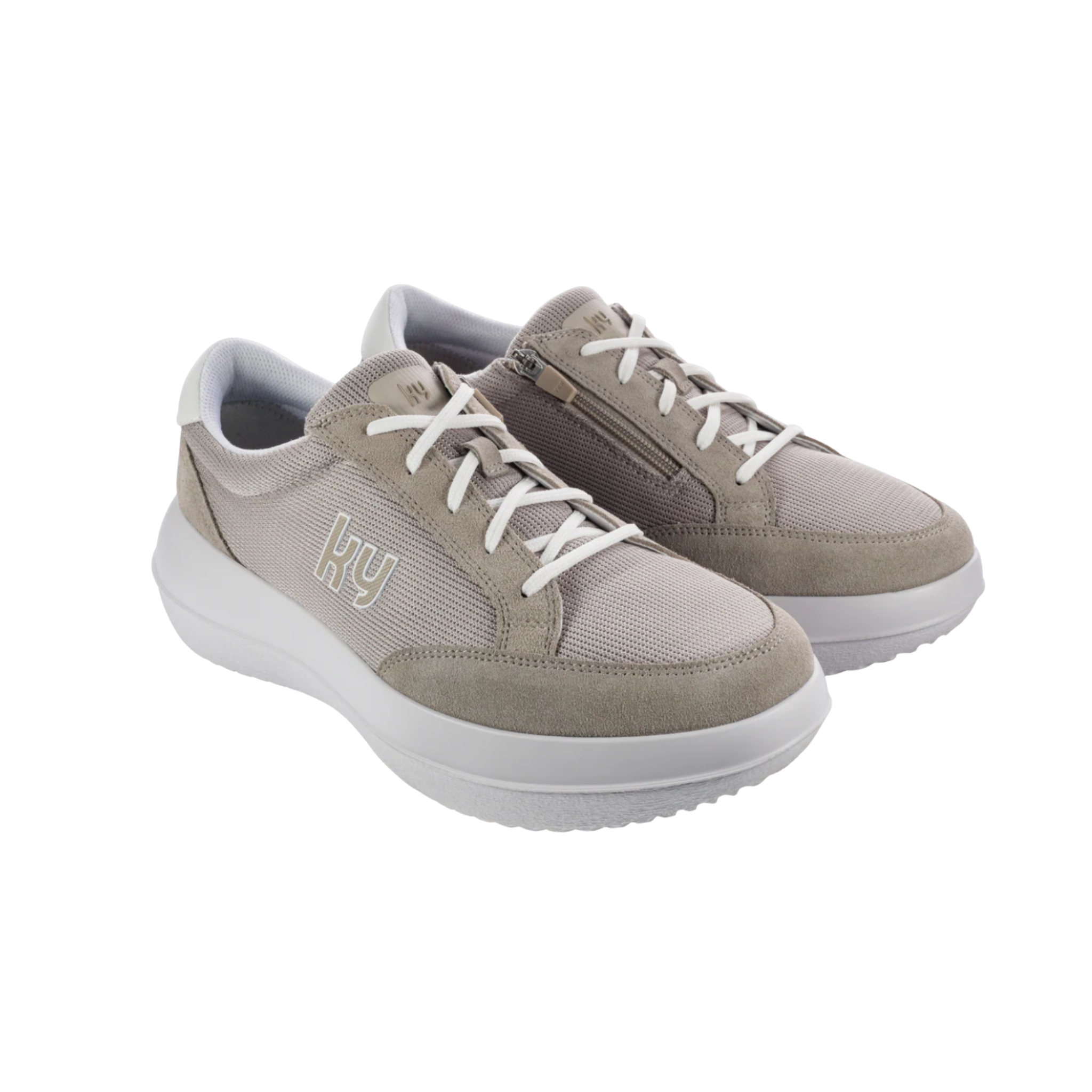 Pair of beige sneakers with white soles on a white background
