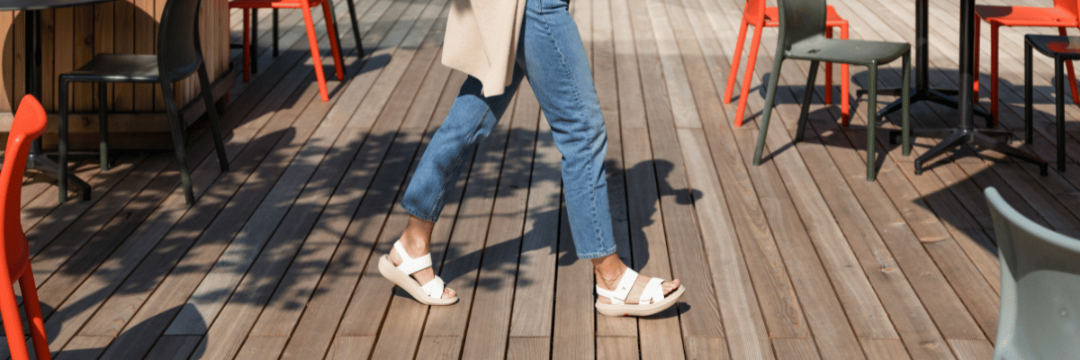 women walking on brown wooden deck wearing white sandals