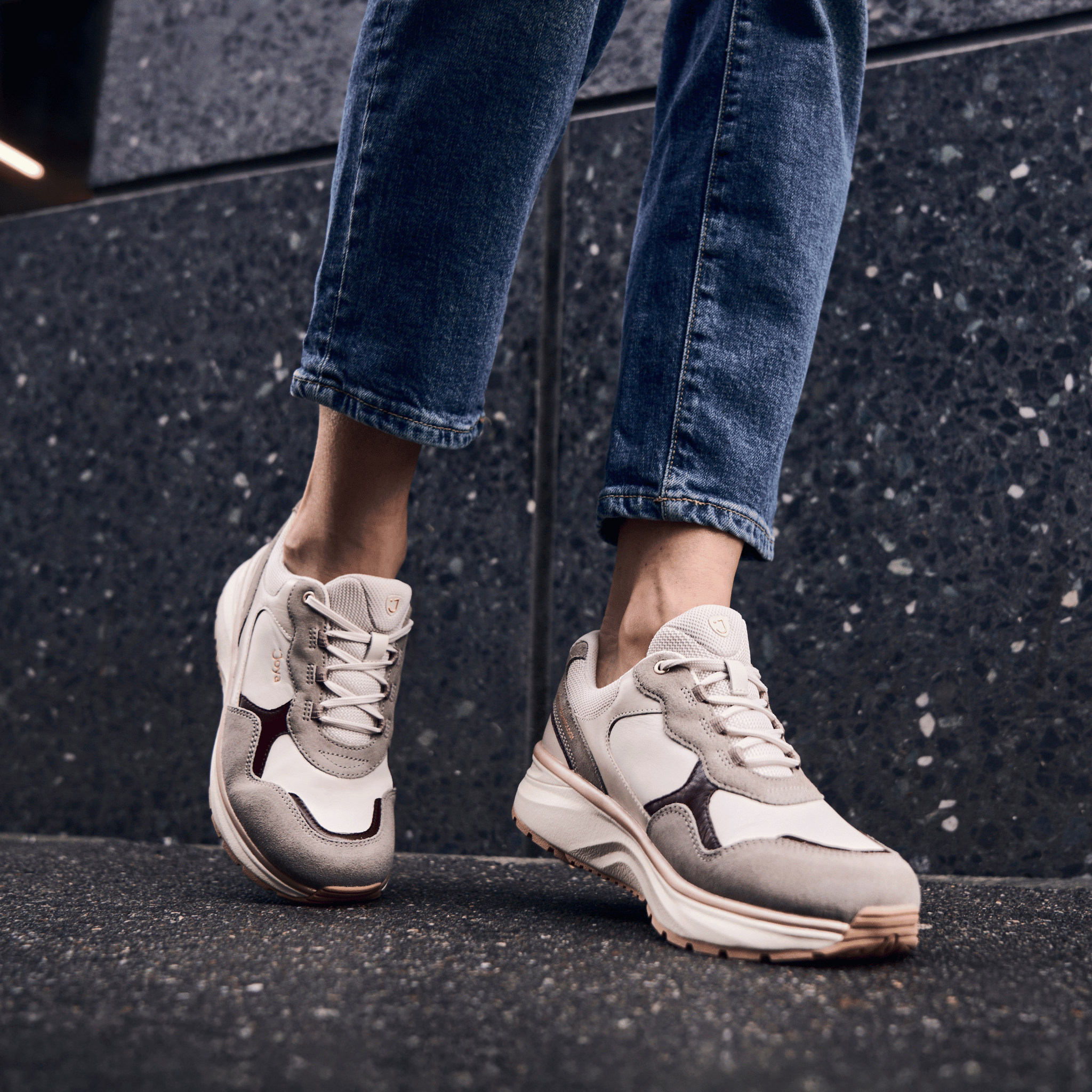 women standing on granite background close up view of beige sneaker
