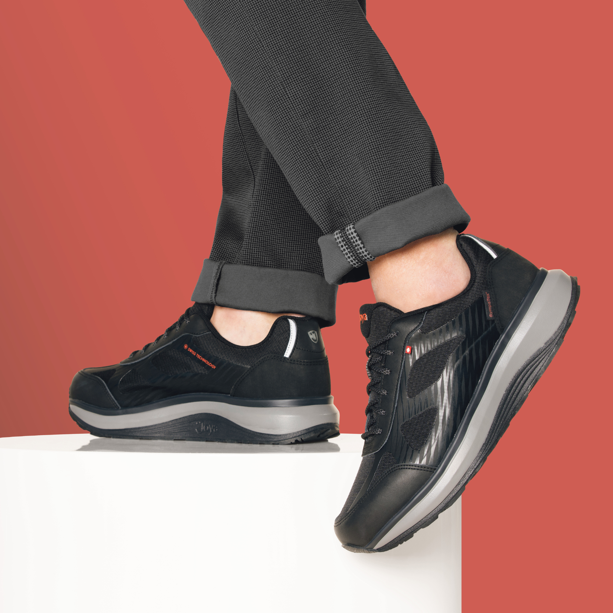 person wearing the Joya Men's Cancun II STX Black Shoe on red background