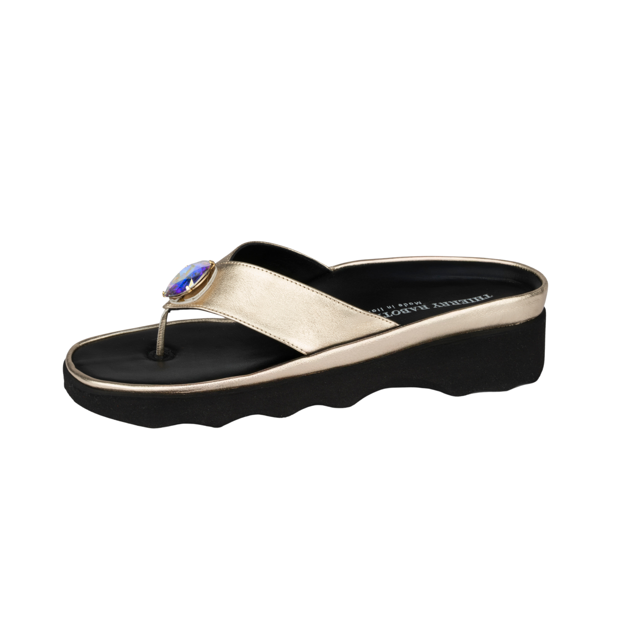 Gold sandal with a black sole on a white background