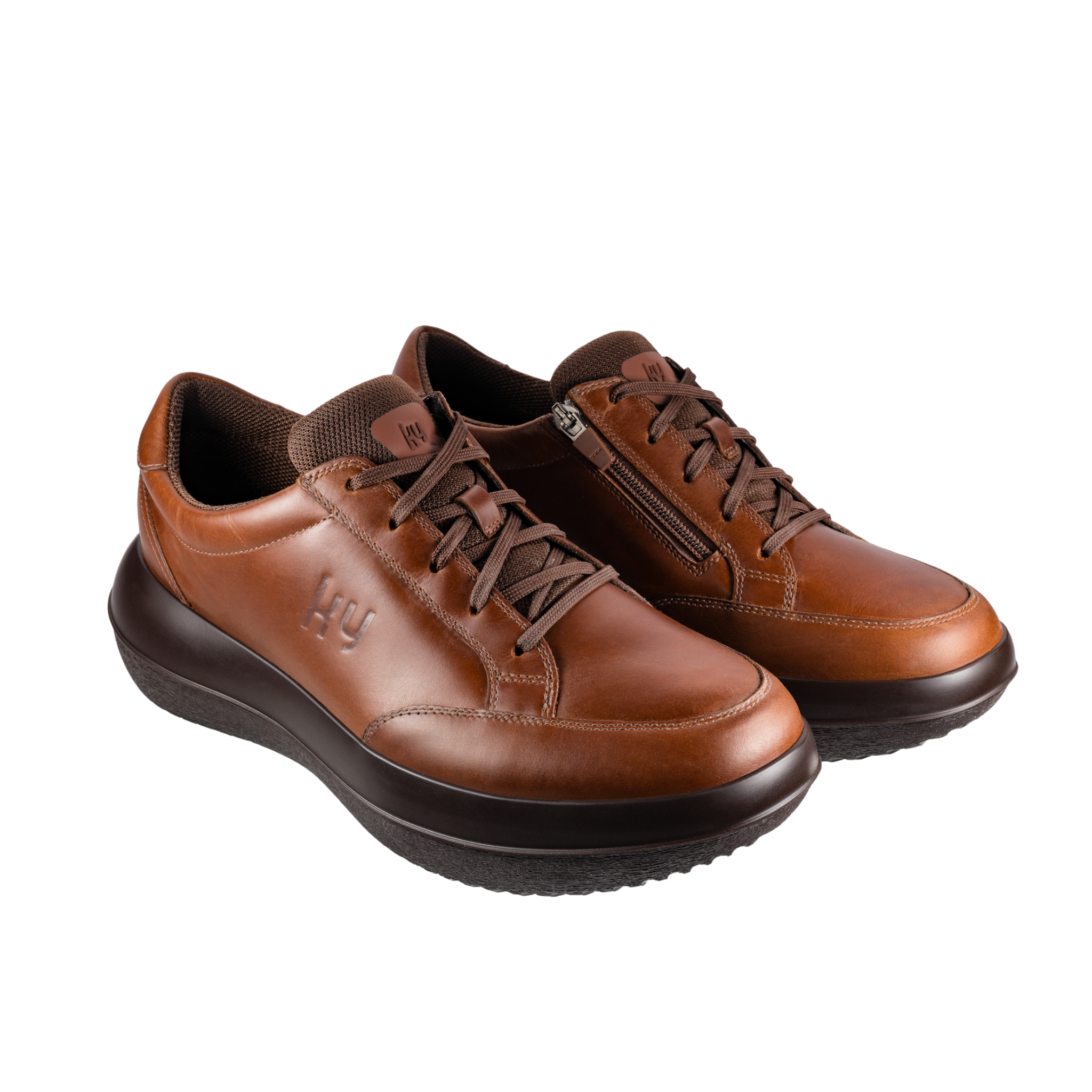Pair of brown leather shoes with black soles on a white background