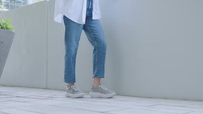 women walking on street in grey sneakers
